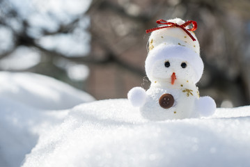 Little snowman on snow. Back sun light