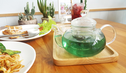 Crystal clear tea pot with green butterfly pea tea and lemonade