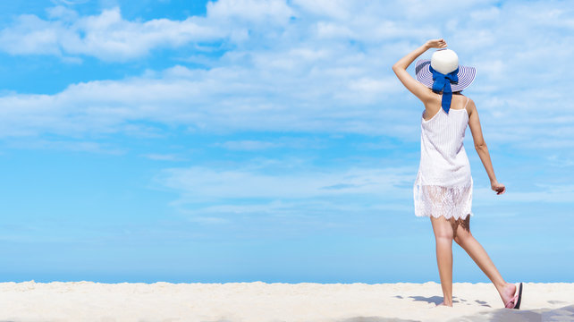 Beautiful woman walking on the beach with blue sky. Happy summer vacation. Picture for add text message. Backdrop for design art work.
