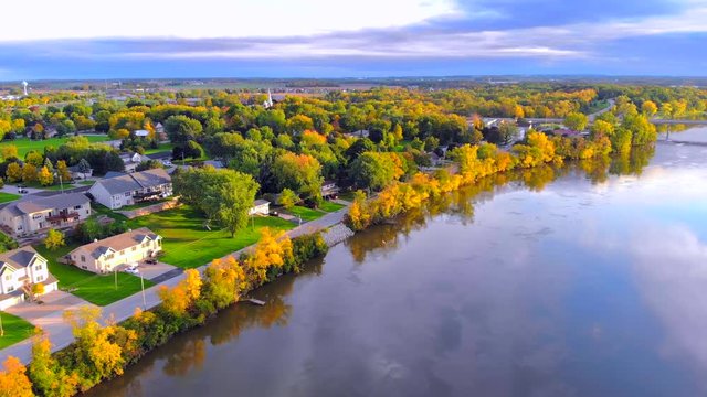 Colorful Autumn river, small town, in the last light of day, moving aerial view.
