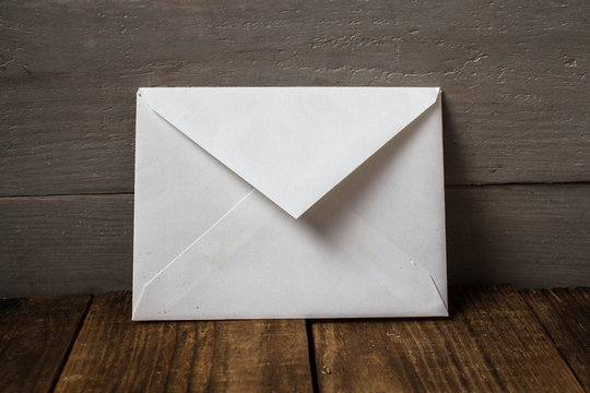 A White Envelope On Grey Wooden Background