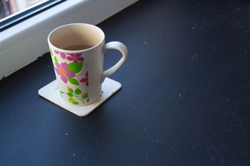 a cup with tea near the window