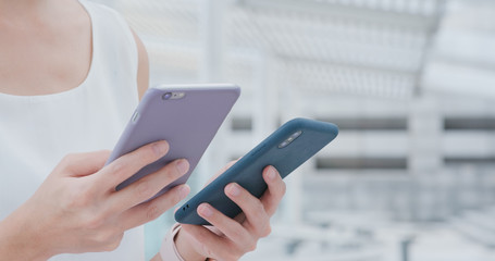 Woman sending data between mobile phone