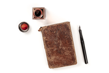 An overhead photo of an ink well with an old journal, with a nib pen and copy space, shot from...
