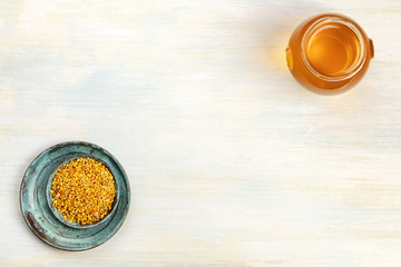 Healthy organic food. An overhead photo of pollen and a jar of honey, shot from above on a light background with copy space