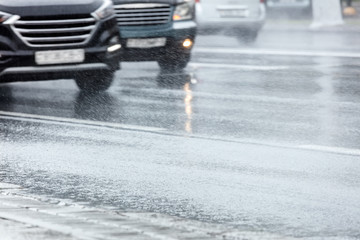 city road during rush hours. cars moving in high speed on wet asphalt road