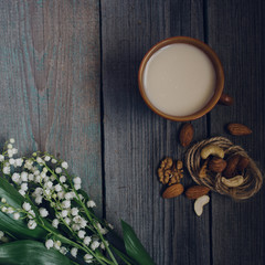 a Cup of tea, nuts, bouquet of lilies on a wooden table