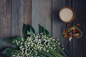 a Cup of tea, nuts, bouquet of lilies on a wooden table