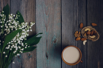 a Cup of tea, nuts, bouquet of lilies on a wooden table