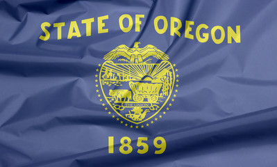 Fabric flag of Oregon. Crease of Oregon flag background, The states of America, cost of arm in gold color on blue field.