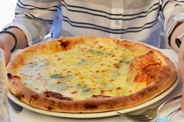 Italian Calzone Pie with cheese on a white ceramic plate in a restaurant