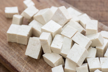 fresh tofu cubes on wooden cutting board