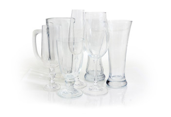 Different empty glass utensils on a white background