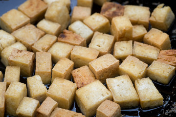 tofu cubes fried in wok