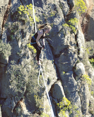 Highliner on a rope. Highline on a background of mountains. Extreme sport on the nature. Balancing on the sling. Equilibrium at altitude.