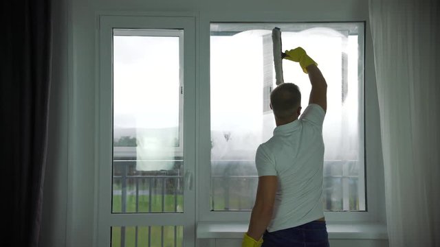 A man from a cleaning company washes Windows