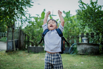 Happy children go back to school.Asian smiling boy jumping with two hands up  going to school for the first time.