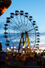 Amusement park on the background of the sunset. Ferris wheel
