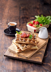 Waffles with fresh strawberry, chocolate sauce and coffee