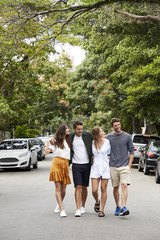 Four friends together walking in street