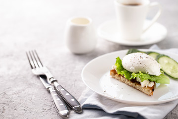 Breakfast with poached egg on toast and coffee