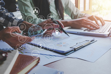 Business team meeting concept,Two colleagues discussing data with smart phone and new modern computer laptop on desk table, with virtual interface icons network diagram.