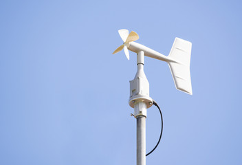Vane style of anemometer against the blue sky.