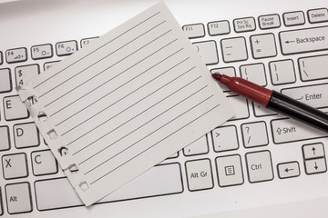 Business concept Empty template copy space isolated Posters coupons promotional material. Blank Torn Notebook Page Uncapped Marker for Writing on Laptop Keyboard