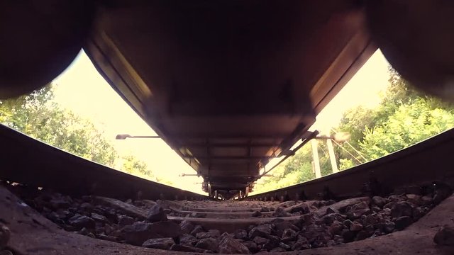 Passing train bottom under view wide angle close-up. Railroad tracks railways train transport system fast speed