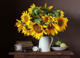 Still life with a bouquet of sunflowers and fruits.