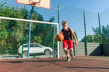 Outdoor portrait street basketball player playing with the ball on sunny day