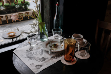 Vintage table set by the window of coffee and dessert in a cafe