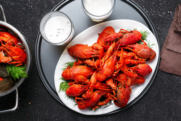 Boiled crawfish dill bay leaf black background lager beer top view