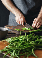 Man cutting green bean wooden cutting board Healthy vegetarian food