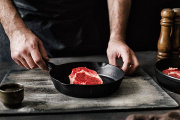 Man cooking beef steak dark background dark style