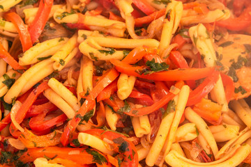 Italian vegetarian food - Pasta with peppers and onions in a pan close-up, top view