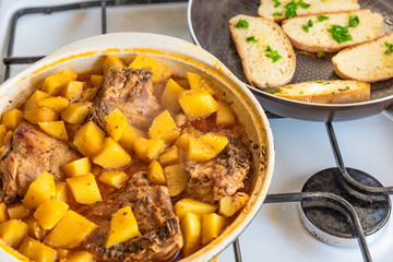 Stewed chicken with potatoes in a pan with onions in tomato sauce