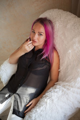 Portrait of a beautiful woman with pink hair in a Chair