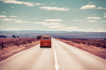 Retro van driving on rural highway passing through the countryside