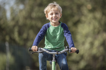 Fototapeta na wymiar Smiling little boy ride on a bicycle