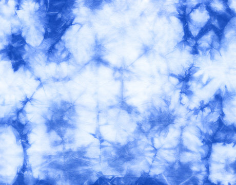 Abstract tie dyed fabric of indigo color on white cotton. Hand painted fabrics. Shibori dyeing