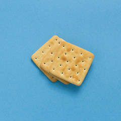 Tasty cookies biscuits on blue colored background, top view