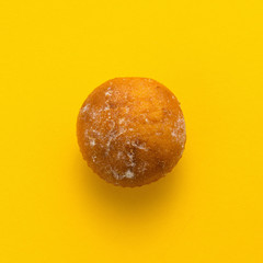 Freshly baked butter croissant on yellow colored background, top view