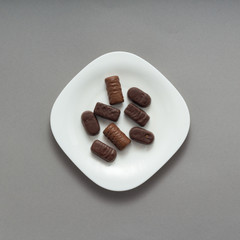 Assortment of chocolate candies sweets on grey background, top view