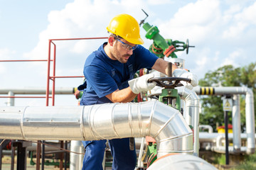 Oil worker turning valve on oil rig
