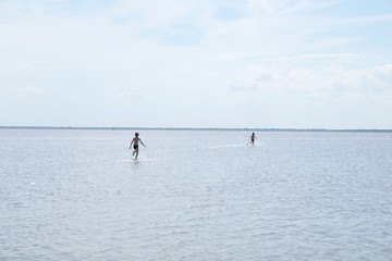 Running children on the surface of lake at summer. Salt shallow lake in Russia. Loneliness  concept in big world