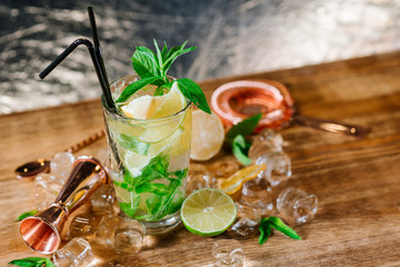 A mojito cocktail with ice in glass on wooden table
