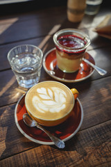 close-up of woman's hands with a cup of coffee cake, the sun's rays shine through a window in the cafe. Hand and cup coffee.