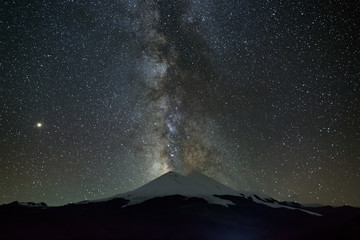 Stars of the Milky Way at night in the sky above Mount Elbrus. View of the northern slope of the...