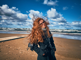 A young girl is walking along the seashore.